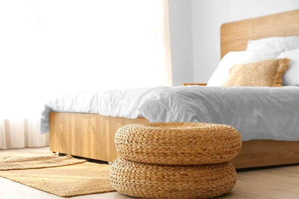 Rattan poufs and carpet in bedroom