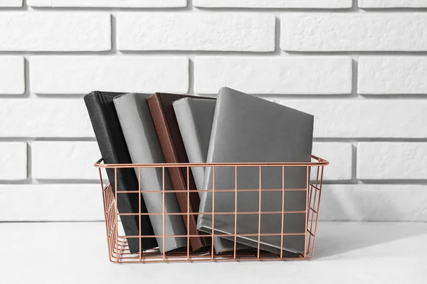 Metal Basket Books Table White Brick Wall — Zdjęcie stockowe