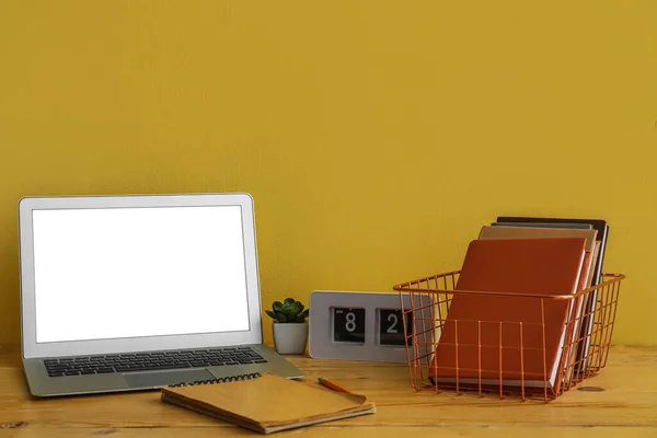 Metal Basket Books Clock Laptop Table Yellow Wall — Stock Photo, Image