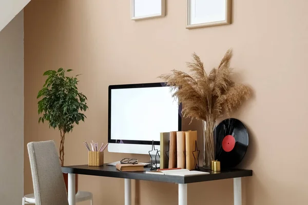 Workplace with computer and books in room