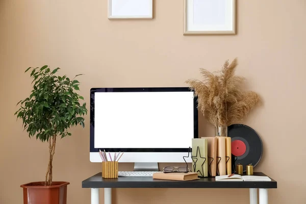 Workplace with computer and books in room