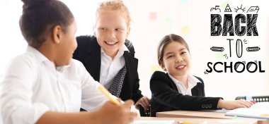 Cute little students during lesson in classroom. Back to school