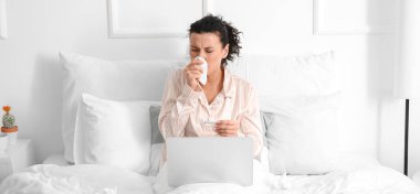 Evde çalışan dizüstü bilgisayarı olan hasta genç bir kadın.