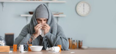 Mutfak masasında oturan hasta adam