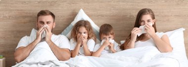 Family ill with flu in bed  