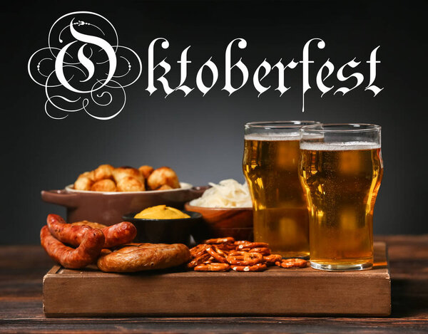 Glasses of fresh beer and snacks on table against dark background. Oktoberfest celebration