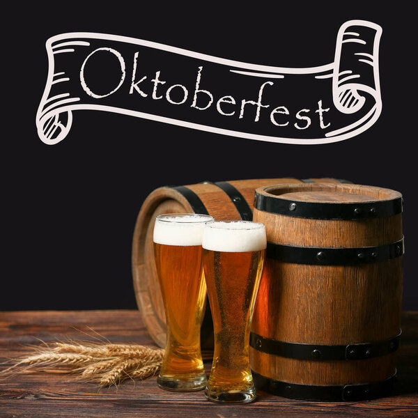 Glasses of fresh beer and barrels on table against dark background. Oktoberfest celebration