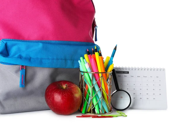 Pen cup with apple, calendar and school backpack on white background