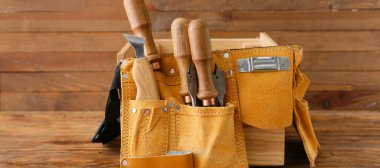 Ahşap arka planda farklı marangoz aletlerine sahip kemer.