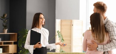 Real estate agent showing young couple their new house