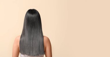 Woman with graying hair on beige background with space for text, back view