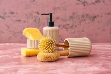 Cleaning supplies and pump bottle on color background