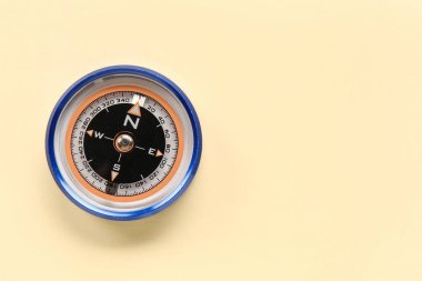 Tourist's compass on beige background