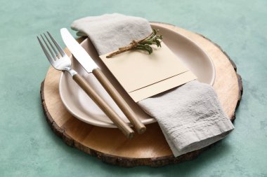 Simple table setting with floral decor on green background