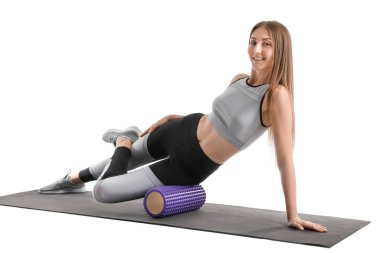 Young woman training with foam roller on white background