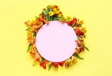 Composition with blank card and alstroemeria flowers on yellow background
