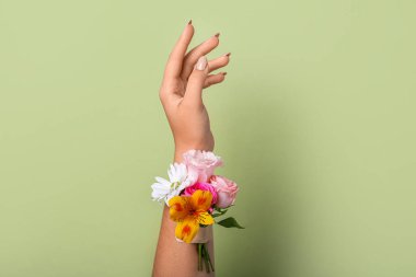 Woman with beautiful flowers and adhesive tape on green background