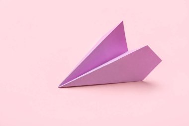 Lilac paper plane on pink background