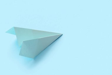 Blue paper plane on color background
