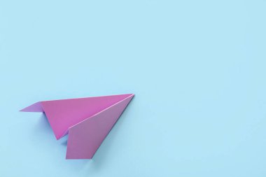 Lilac paper plane on blue background