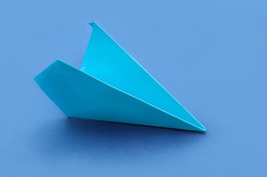 Blue paper plane on color background