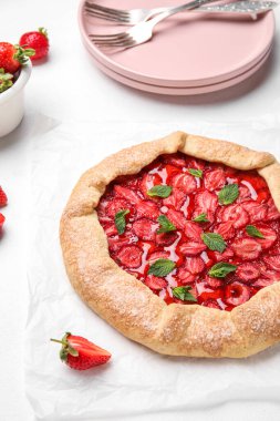 Delicious strawberry galette on light background