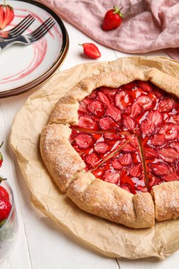 Sweet strawberry galette on light wooden table, closeup