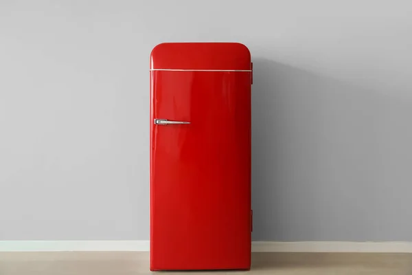 Stylish retro fridge near light wall