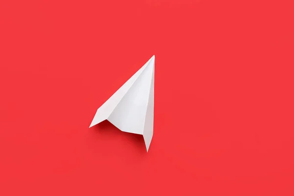 White paper plane on red background