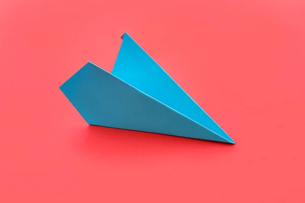 Blue paper plane on red background