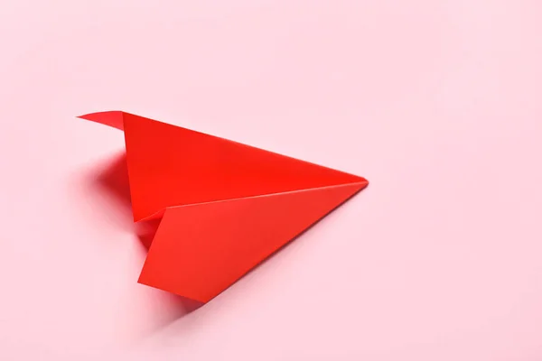 ピンクの背景の赤い紙飛行機は — ストック写真