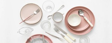 Set of stylish dinnerware and cutlery on white background, top view