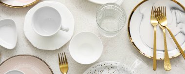 Set of stylish dinnerware and cutlery on light background, top view