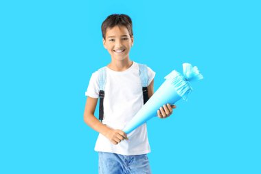 Little boy with school cone on blue background