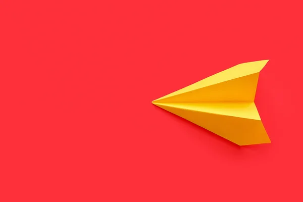 Yellow paper plane on red background