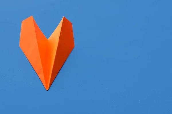 Orange paper plane on blue background