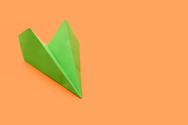 Green paper plane on orange background