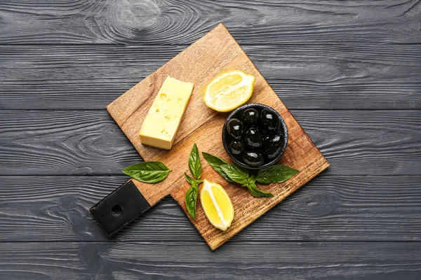 Board Bowl Tasty Black Olives Lemon Cheese Basil Dark Wooden — Stock Fotó