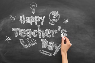 Hand writing text HAPPY TEACHER'S DAY on school blackboard