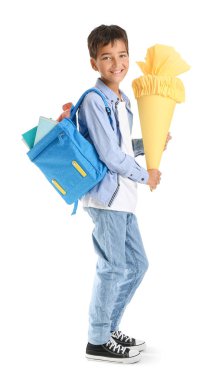 Little boy with yellow school cone and backpack on white background