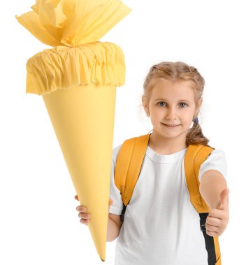 Cute little girl with yellow school cone and backpack showing thumb-up on white background