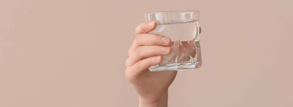 Female Hand Holding Glass Water Beige Background — Stockfoto