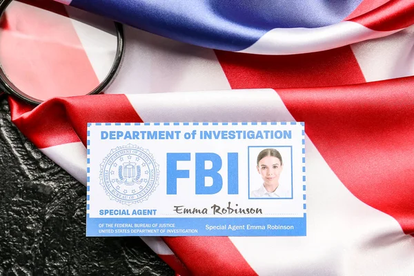 Flag of USA, document of FBI agent and magnifier on dark background