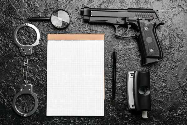 Ноутбук Канцелярскими Принадлежностями Увеличителем Пистолетом Наручниками Темном Фоне — стоковое фото