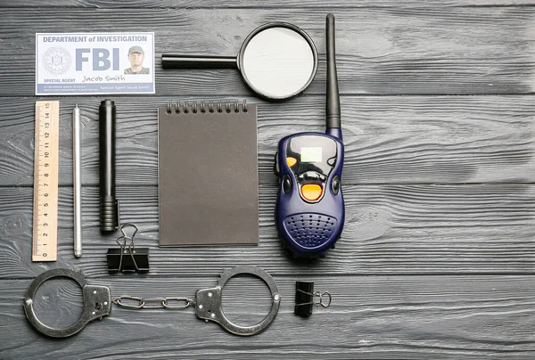 Accessories of FBI agent on dark wooden background