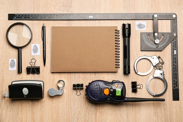Notebook and accessories of FBI agent on wooden background
