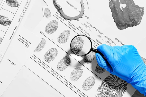 Forensic expert studying prints of criminal