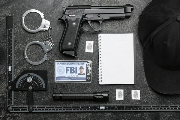 Notebook with document of FBI agent and accessories on dark background