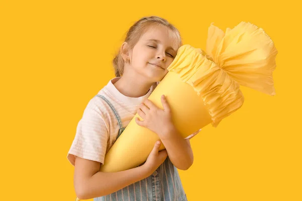 Cute Little Girl Hugging School Cone Yellow Background — Fotografie, imagine de stoc