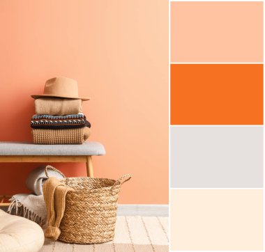 Bench with warm winter sweaters, felt hat and wicker basket near color wall in room. Different color patterns